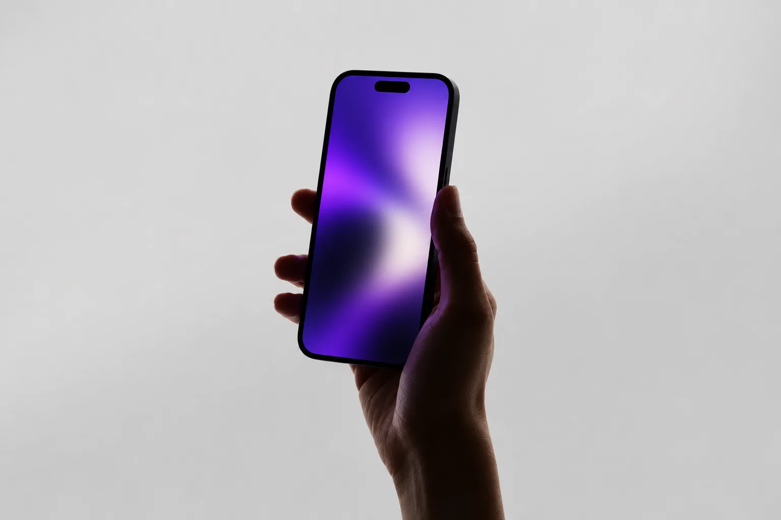 Conceptual image of a silhouetted hand holding a phone with blurred purple light