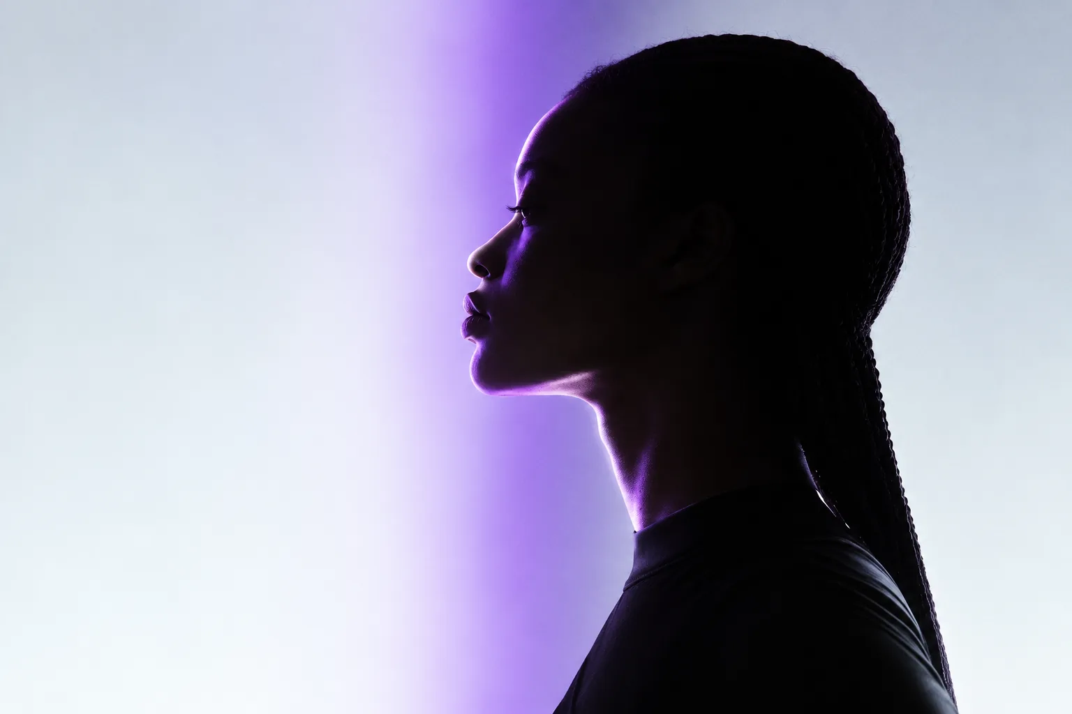 Conceptual image of a side-profile silhouette moving between shadow and purple light