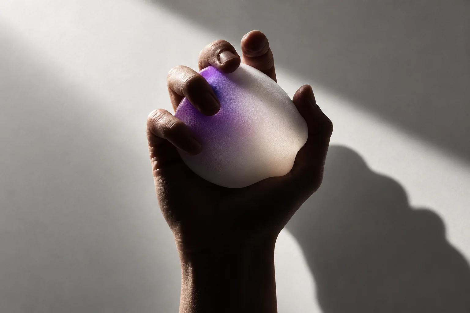 A hand securely holding a luminous material form, representing clearly defined scope