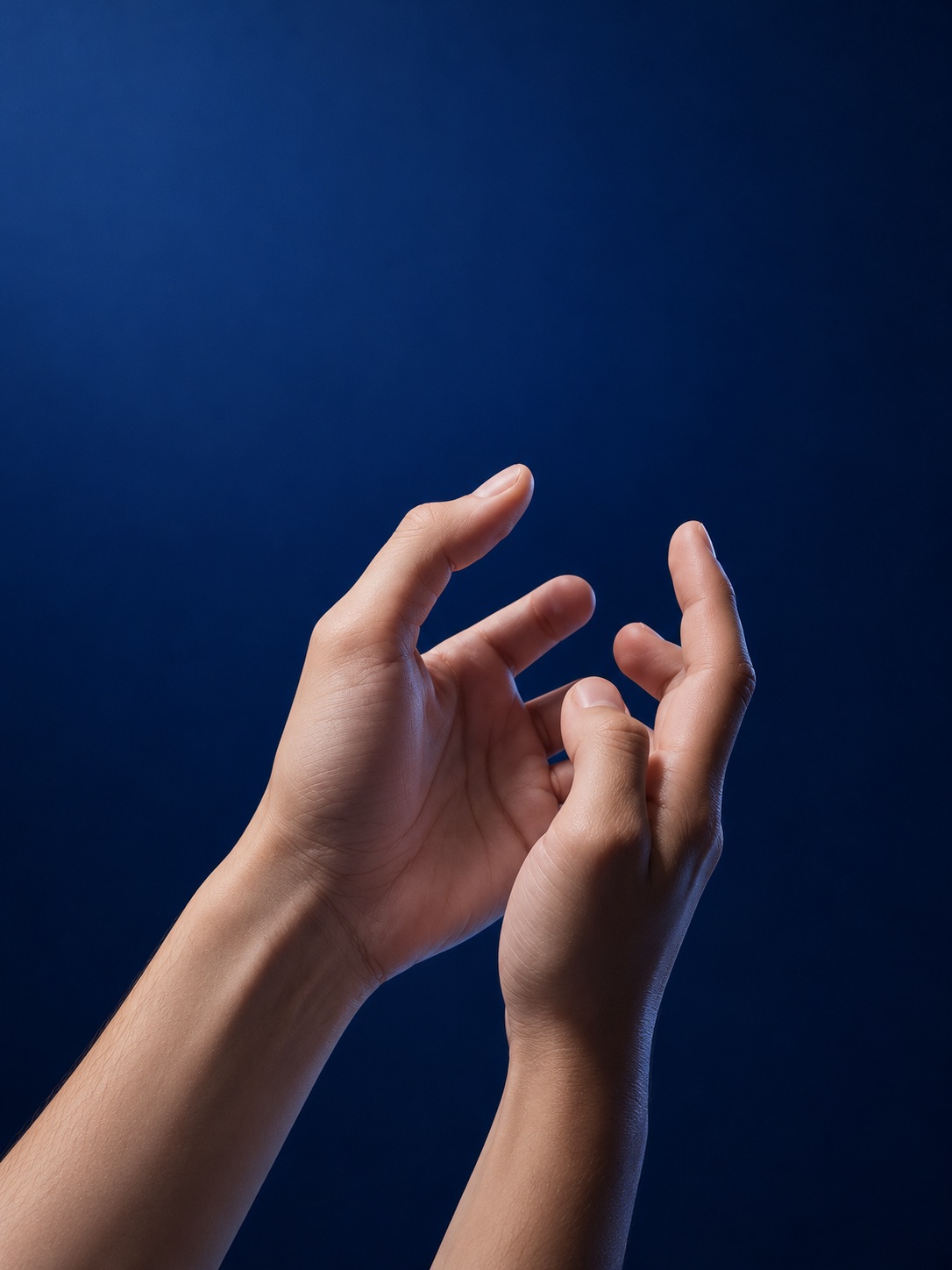 Close-up of two hands on a deep blue studio background